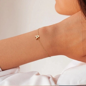 Détail d'un bracelet en acier doré avec pendentif en forme de lettre A en 3D