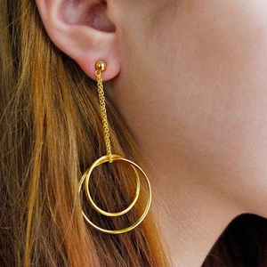 Close-up of gold stainless steel long tassel earrings featuring layered double circles