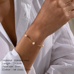 Detailed macro view of 5mm pearls on a fine 14K gold stainless steel chain bracelet