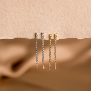 Gros plan de boucles d'oreilles pendantes élégantes serties de zircons en argent et doré