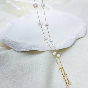 Close-up of golden star pearl bracelet with white pearls on a silk background