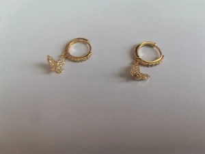 Close-up of gold butterfly drop earrings with sparkling pavé crystals and hoop closure
