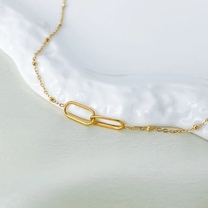 Detailed close-up of interlocking gold paperclip link necklace with dainty satellite chain