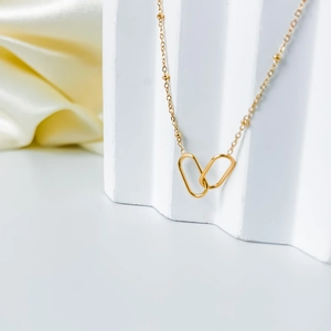 Detail of 18K gold satellite chain necklace featuring interlocking oval loop pendants