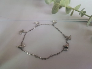 Détail du bracelet papillon argenté avec cinq breloques scintillantes serties de zircons
