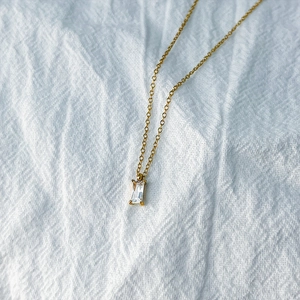 Detailed close-up of a square zircon pendant on a gold stainless steel chain necklace