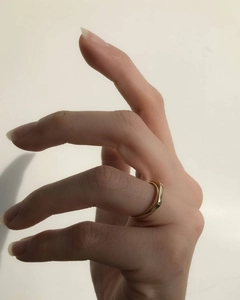 Detail shot of a minimalist 18K gold plated signet ring worn on a finger