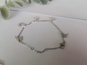 Détail d'un bracelet papillon argenté avec cinq pendentifs brillants et fermoir