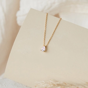 Détail d'un pendentif en zircon blanc taillé en poire sur une fine chaîne dorée