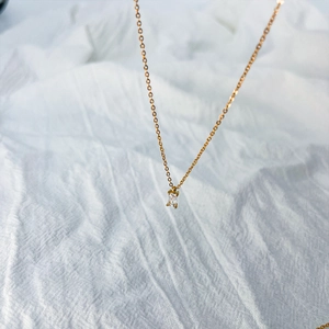Macro view of gold pendant necklace with square-cut zircon and fine cross chain