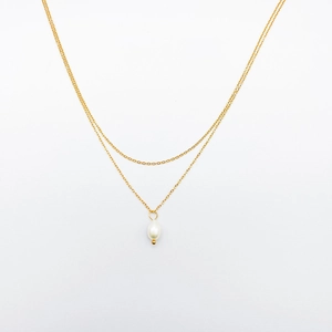 Détail d'un collier doré double rang orné d'un pendentif perle blanche en goutte