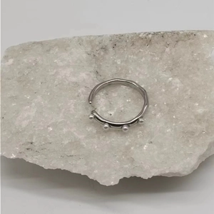 Detailed shot of wave texture silver steel ring with four delicate white pearls