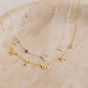 Detalle de collares de acero inoxidable personalizados con colgantes de MAMA y LVE