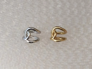 Detailed view of silver and gold knotted twist rings in minimalist stainless steel style