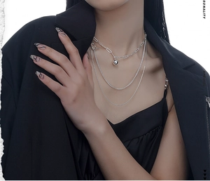 Détail du collier triple rang en argent sterling S925 sur un costume noir chic