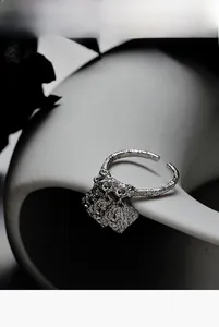 Artistic close-up of S925 silver textured open ring with dual square metal charms