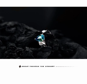 Macro detail of S925 silver ring featuring a pear-cut blue stone on dark rock texture