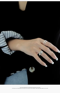 Detail of S925 sterling silver textured ring set with diamond accents and charms
