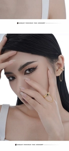 Détail de la bague à chaîne et de la manchette d'oreille dorées avec pierres noires