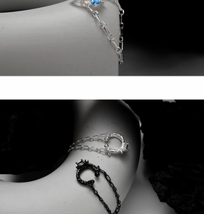Vue détaillée des boucles d'oreilles S925 en argent avec pierre bleue et finition noir mat