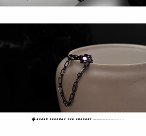 Détail de la bague chaîne en métal noir avec pierre précieuse violette carrée