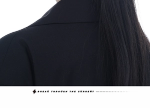 Gros plan sur le tissu tissé noir d'un blazer minimaliste porté par un mannequin