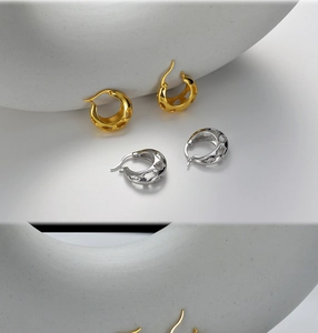 Gros plan sur des créoles en argent sterling S925 or et argent avec motifs étoiles évidés