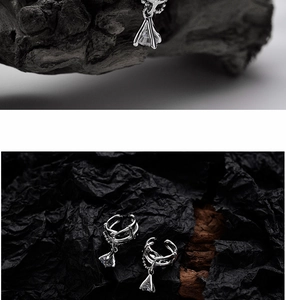 Macro view of irregular hollow silver ear cuff with dangling clear cubic zirconia charm