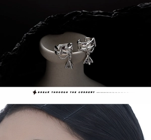 Detail of silver S925 chain ear cuff with sparkling triangle crystal and metal layers