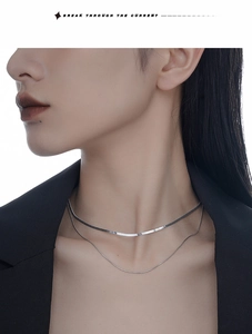 Nahaufnahme einer zweilagigen S925 Silber Schlangenkette an Model in schwarzer Kleidung