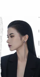 Detail of silver tassel earrings with purple gemstone on fashion model in studio