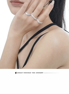Detailed view of silver stackable rings with unique organic texture on model's hand