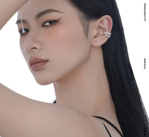 Macro view of irregular silver ear cuff with sparkling zircon and delicate chain details