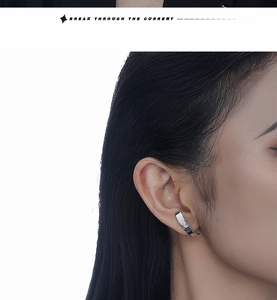 Close-up of irregular silver ear cuff with mirror-polished finish on model's ear