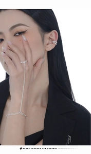Close-up of S925 silver finger bracelet and ear cuff set worn by a fashion model