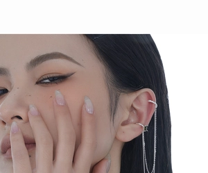 Close-up of S925 silver ear cuff with green zircon stone and delicate chain tassels