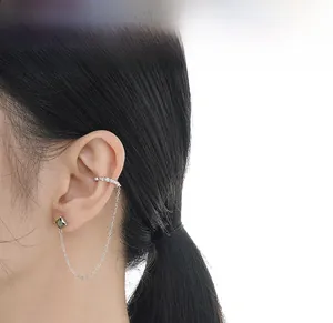 Detail of S925 silver chain earring with emerald green gem and sparkling cuff