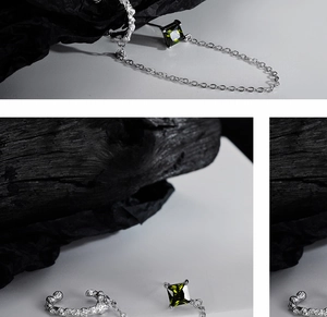 Detail of silver lava texture ear cuff with emerald stud and connecting chain
