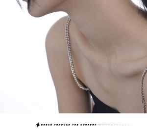 Detail view of slender silver chain shoulder straps on a sleek black slim-fit garment