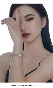Close-up of multilayered 925 sterling silver bracelet with baroque pearl on female wrist