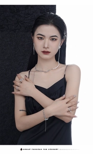 Asian model wearing silver tassel earrings and layered pearl chain jewelry set