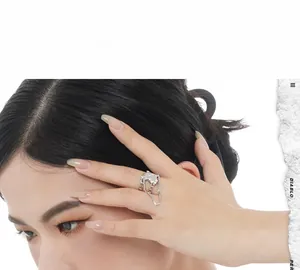 Detail of silver S925 sterling silver lava ring with dangling chain on female finger