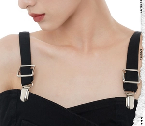 Macro detail of wide black fabric straps with silver metal adjusters and clips