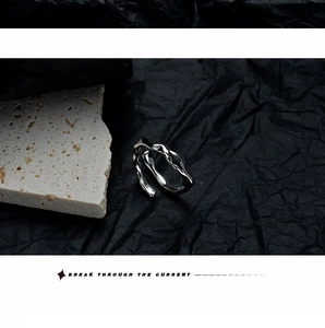 Detailed view of S925 sterling silver wavy irregular ring on dark textured paper