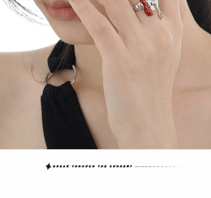 Close-up of irregular lava ring with red enamel finish on a female model's finger