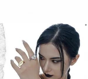Dettaglio di anelli geometrici oversize in oro e argento con trame irregolari e uniche