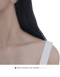Minimalist S925 silver ear cuff with streamlined knot design shown on model's left ear