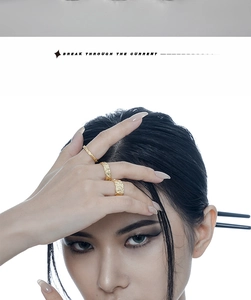 Close-up of gold rings with irregular hammered texture on a model in a minimalist style