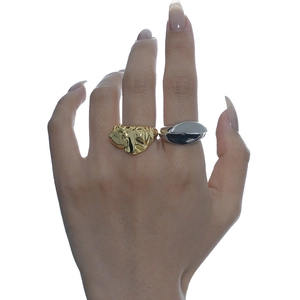 Anello dorato plissettato e anello geometrico liscio argentato sulla mano femminile