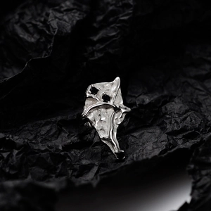 Irregular silver textured ring with black zircon stones on crinkled black paper